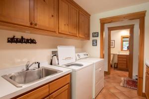 a kitchen with a sink and a washing machine at Pristine waterfront oasis plus game room jacuzzi and home office in Orleans +34 photos