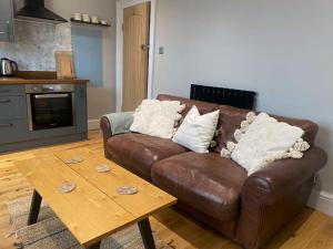 a living room with a brown couch and a wooden table at Charming and Stylish Redland One Bedroom Apartment in Bristol