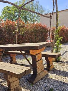 - une table de pique-nique en bois et un banc dans le jardin dans l'établissement Apartma Kras, à Komen