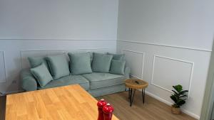 ein Wohnzimmer mit einem Sofa und einem Tisch in der Unterkunft Apartament Pastelove Żywiec in Żywiec