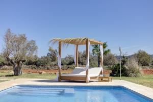 ein Bett und ein Pavillon neben einem Pool in der Unterkunft Reina de la Isla by Rentallorca in Felanitx