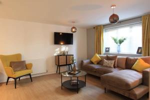 ein Wohnzimmer mit einem Sofa und einem Stuhl in der Unterkunft Cabot Mews Apartment 3 in Bristol