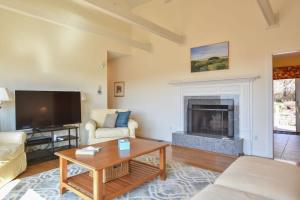 a living room with a tv and a fireplace at Water Views & Private Tennis Court in Barnstable