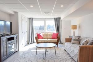 a living room with a couch and a table at Water Views & Private Tennis Court in Barnstable