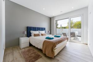 Un dormitorio con una cama grande y un balcón. en Villa Almargens, en São Brás de Alportel 40 fotos más