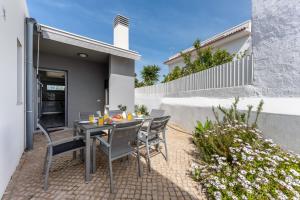 un patio con mesa y sillas en un patio trasero en Villa Almargens, en São Brás de Alportel