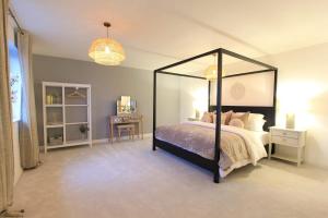 Cabot Mews Apartment 9 في بريستول: غرفة نوم مع سرير المظلة وطاولة