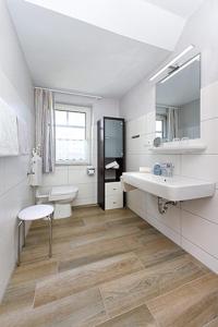 ein weißes Bad mit einem Waschbecken und einem WC in der Unterkunft Landhaus am Grafthof in Neuharlingersiel