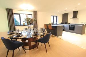 Cabot Mews Apartment 9 في بريستول: غرفة طعام ومطبخ مع طاولة وكراسي