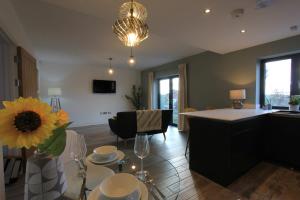 a kitchen and living room with a table with a sunflower at Cabot Mews Apartment 4 in Bristol