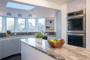 a kitchen with a wooden bowl of fruit on a counter at Famous Architectural Home in quiet forests of Truro in Wellfleet