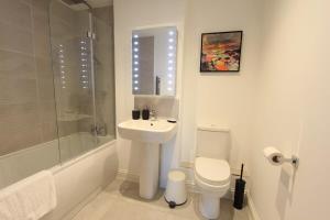 een witte badkamer met een wastafel en een toilet bij Cabot Mews Apartment 6 in Bristol