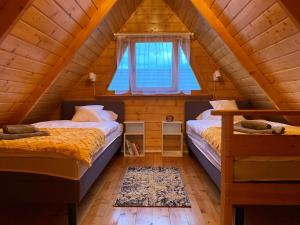 twee bedden in een kamer met een zolder bij Cudowny Świat in Rożnów