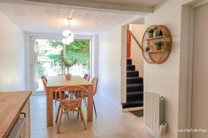 a kitchen and dining room with a table and chairs at L'Orée du Golf - Maison Deauville 8 personnes in Saint-Arnoult