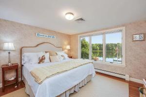 een slaapkamer met een groot bed en een raam bij Waterfront Incredible Views and Private Dock in Yarmouth