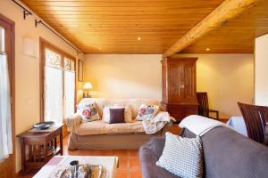 a living room with a couch and a wooden ceiling at Mas Cal Gintó in Das