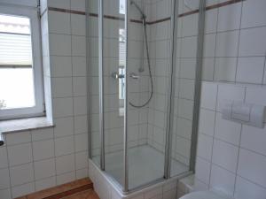 um chuveiro com uma porta de vidro na casa de banho em Ferienwohnung LVC11 em Graal-Müritz