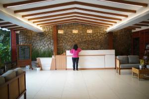 a woman standing at a counter in a room at Rivulet Resort in Munnar