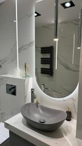 a bathroom with a sink and a large mirror at Apartament Pastelove Żywiec in Żywiec