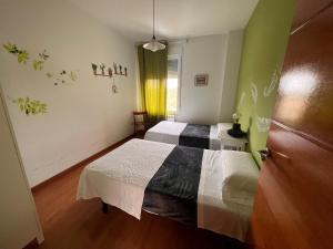 a bedroom with two beds and a window and a door at Casa Laureana in Ruidera