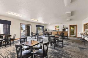 a restaurant with tables and chairs and a kitchen at Quality Inn Cheyenne I-25 South in Cheyenne