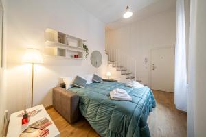 ein Schlafzimmer mit einem Bett, einem Tisch und einer Treppe in der Unterkunft City centre Beautiful house with garden in Bologna