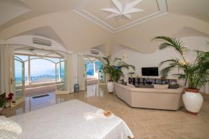 - un grand salon avec un canapé et une table dans l'établissement Villa Santa Chiara Positano Suites, à Positano