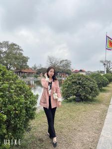 a woman standing next to a river with a flag at PHÚ TRANG HOTEL in Ha Long