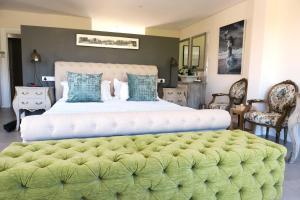 a bedroom with a large bed with a green ottoman at Villa du Soleil Plettenberg Bay in Plettenberg Bay