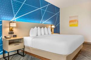 una habitación de hotel con una cama grande y una mesa auxiliar en Comfort Inn & Suites Rapid City near Mt Rushmore, en Rapid City