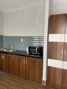 uma cozinha com um lavatório e um micro-ondas no balcão em My House Hotel em Da Lat