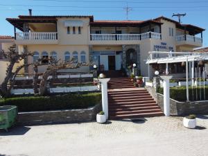 a large house with stairs in front of it at Polychrono Beach Hotel in Polykhrono