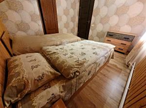 een slaapkamer met 2 bedden en een houten vloer bij Forest Gamp in Dilidzjan