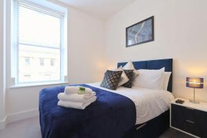 a bedroom with a blue bed with towels on it at Alliance 209 in Bristol