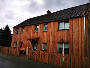 een houten huis met een hek ervoor bij Ferienhaus Emilia in Wilthen