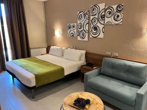 a hotel room with a bed and a couch at Pensión Iznájar Barcelona in Barcelona