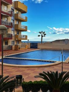 a large swimming pool in front of a building at Apartamento Las Brisas, Atico in Puerto de Mazarrón