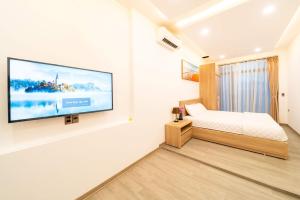a bedroom with a flat screen tv on a wall at 2CE APARTMENT & HOTEL in Hai Phong