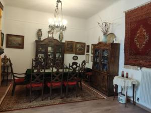ein Esszimmer mit einem Tisch, Stühlen und einem Kronleuchter in der Unterkunft Casa Oliver in Athen