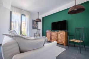 a living room with a white couch and a tv at Ninai Sea Holiday Apartment 2 in Furci Siculo