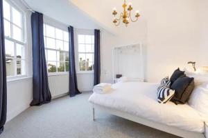 1 dormitorio blanco con 1 cama y 2 ventanas en Kingsdown 2 bed en Bristol