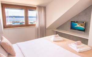 a bedroom with a bed and a window and a tv at Apartments Portun Top Center in Baška Voda