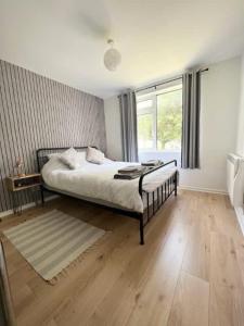 a bedroom with a bed and a large window at Montague central one bedroom flat with parking in Bristol