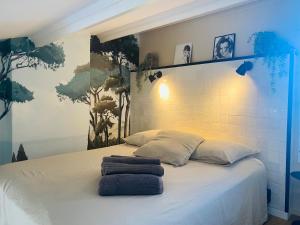 una camera da letto con un letto con due asciugamani sopra di VILLA NATURISTE HELIOVILLAGE - CAP D'AGDE - 2 PERS a Cap d'Agde