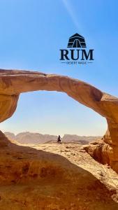 une personne debout dans le désert sous une arche dans le labyrinthe du désert dans l'établissement Rum desert magic, à Wadi Rum