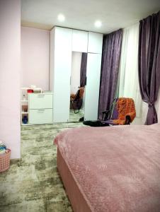 um quarto com uma cama rosa e um espelho em Nice home in centre em Yerevan