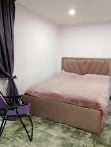 uma cama e uma cadeira num quarto em Nice home in centre em Yerevan