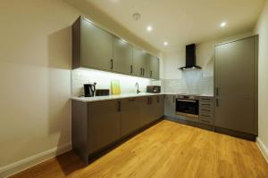 a kitchen with gray cabinets and a wooden floor at Hotwells apartments flat 2 - Hopewell in Bristol