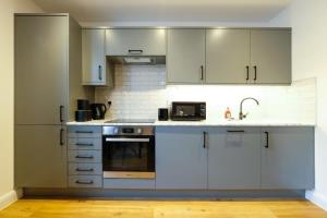 eine Küche mit weißen Schränken und einem Waschbecken in der Unterkunft Hotwells apartments flat 1 - Hopewell in Bristol