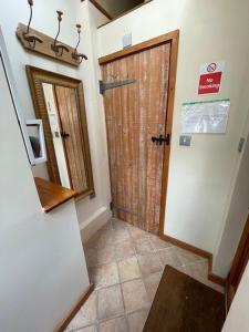 a hallway with a wooden door in a house at Cobwebs in Kedington